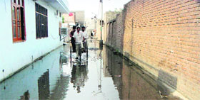 A rickshaw-puller takes residents through a street flooded with sewar water. 