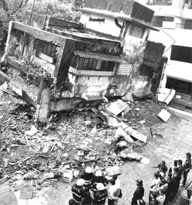 Rescue workers near a four-storey building which collapsed in Mumbai on Wednesday