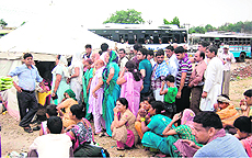 Passengers wait at a makeshift bus station on the Rishikul ground in view of Kanwar Mela in Haridwar on Thursday. 