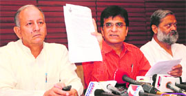 BJP national secretary Kirit Somaiya (centre) shows land scam documents at a press conference in Chandigarh on Thursday.