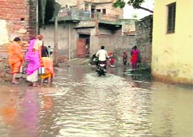 A motorist drives through a waterlogged street after rain in Nuh (Mewat district) on Wednesday