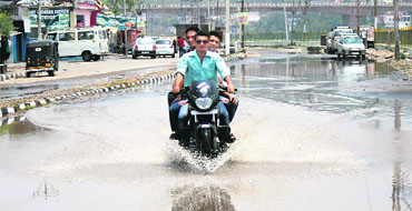 A motorcycle makes its way through a waterlogged road near Dogra Chowk in Jammu on Thursday. 
