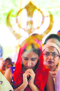 Devotees pay their obeisance on the birth anniversary of Guru Hargobind at a gurdwara in Jammu on Thursday.