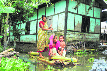 A family moves to a safer place with the help of a banana raft from the flooded Bamunbari village in Kamrup district of Assam on Thursday.