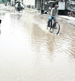 A cyclist passes through stagnant rainwater on Lawrence Road in Amritsar.