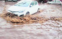Motorists drive through water accumulated due to heavy rain in Patiala. 