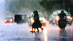Motorists switch on the headlights of their vehicles near the UT Guest House amid dark clouds and rain in Chandigarh on Friday. 