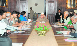Governor Aziz Qureshi holds a meeting with officers of the district administration in Nainital on Friday.