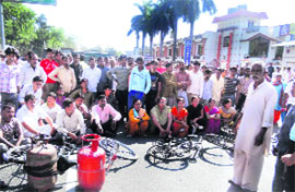 People hold a protest against black marketing and shortage of LPG cylinders outside a gas agency in Haridwar on Friday. 