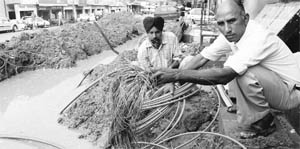 BSNL employees repair a damaged cable at Sohana village near Mohali on Saturday.