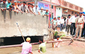 Rescue operation in progress in a drain at the Manav Chowk area in Ambala City on Saturday. 