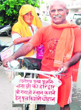 A man from Bulandshahar with his mother on way to Haridwar during the Kanwar mela to fetch Ganga jal from Braham Kund and Har-ki-Pauri