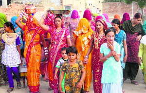 Women proceed towards a well for 'kuan poojan' ceremony on the birth of a girl child at Farwai Kalan village in Sirsa on Saturday.