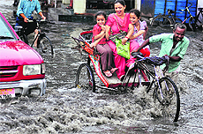 A woman and her children on a rickshaw enjoy the weather after rain in Ludhiana on Saturday. 