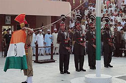 A BSF soldier folds the Tricolour in the Pakistani territory during the retreat ceremony at the Hussainiwala border while Pakistani Rangers present the guard of honour