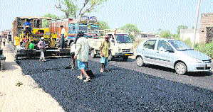 The work on recarpeting the National Highway 703 in full swing in Shahkot near Jalandhar on Sunday.
