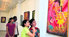 Students take a look at a painting at the ongoing art exhibition at Virsa Vihar in Jalandhar on Saturday.