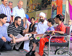Members of the Bharat Vikas Parishad distribute artificial limbs among the differently abled in Ludhiana