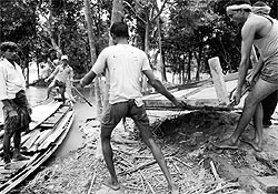 Residents retrieve their belongings in the flood-affected village of Pajarbhanga in Barpeta district, about 95 km from Guwahati, on Sunday