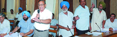 Bathinda MLA Sarup Chand Singla, along with Mayor Baljit Singh Beerbehman and Senior Deputy Mayor Tarsem Goyal (left) and Congress councillors (right) Darbara Singh, Rajan Garg and Jagroop Singh Gill discuss the agenda during the House meeting of the Municipal Corporation on Monday.