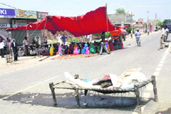 Residents place Dalit youths body on a cot during a blockade of the Bhiwani-Rohtak road on Monday. 