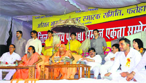 Swami Ramanand Achayra Hansdev (centre) flanked by Swami Dharamdev to his right and Ashwani Chopra to his left at a Punjabi sammelan in Fatehabad.