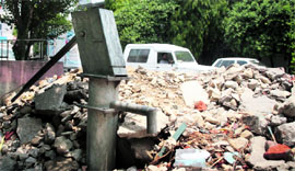 A public hand pump burried under debris near Durga Temple in the Ram Pura area of Jammu.