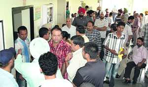 Applicants for fancy numbers of vehicles wait for the start of the auction outside the District Transport Office in Jalandhar on Monday. 