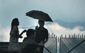 A family shelters itself under an umbrella from a heavy monsoon shower in Shimla. 