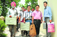 Election officials carry electronic voting machines to be used for the Dasuya bypoll. 