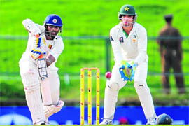 Sri Lankas Thisara Perera plays a shot as Pakistani wicketkeeper Taufeeq Umar looks on during the third day of the third Test in Pallekele on Tuesday.  