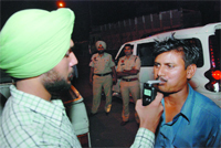 A cop checks a man with an alcometer; cops issue challan (below) at Fauji Chowk on Tuesday night. Tribune photos: Pawan Sharma