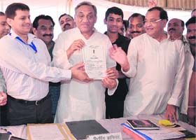 Uttarakhand Chief Minister Vijay Bahuguna receives his election certificate from the Returning Officer after winning Sitarganj bypoll on Wednesday