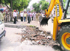 A GLADA team clears encroahments on road berms in Sector 32-A on the Chandigarh Road in Ludhiana on Thursday.