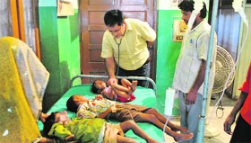 A doctor examines children at a private hospital in Patiala on Thursday.
