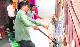 MC employees remove encroachments at Krishna Market, Sector 41, in Chandigarh on Friday.