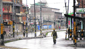 A security personnel patrols a street in downtown Srinagar on Friday. The authorities deployed security forces in the city to prevent separatist protests.