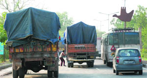 Trucks parked on a road near a tax barrier at the entrance of Chandigarh can cause an accident.
