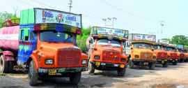 Water tankers wait for their turn to get filled up in front of a water station in Jammu.