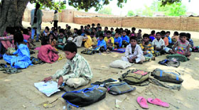 Students of Khalsa Primary School in Muktsar town attend a class under a tree.