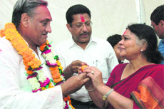 Chief Minister Vijay Bahuguna is offered sweets by his wife Sudha Bahuguna on his electoral victory.