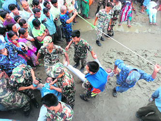 Nepalese army and police personnel carry the victims of a bus accident near the pilgrimage site of Triveni, Nawalparasi, in Nepal.