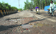The potholed road leading to Gurunanak Pura level crossing from Ladowali in Jalandhar. 