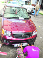 A worker affixes a security plate to a car at the old RTO office in Jammu. Tribune photo: Anand Sharma 