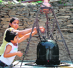 Girls offer water to Lord Shiva at Aganger Mahadev Khaniya, near Dharamsala, on Tuesday.