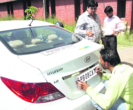A high-security number plate being fitted on a car in Jalandhar.