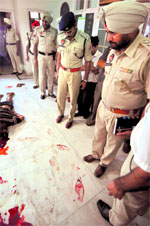 Police officials inspect the double murder site in Ludhiana on Tuesday.