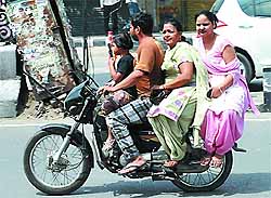Making the most of the available space, four members of a family enjoy a ride on a motorcycle in Bathinda