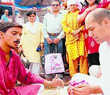 Former IPS officer Kiran Bedi (in yellow dress) looks on as a family member performs rituals of her deceased sister at Braham Kund in Haridwar on Wednesday