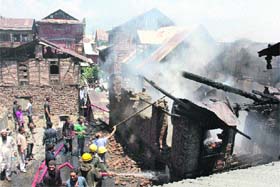 Firefighters douse flames after a few houses caught fire in downtown Srinagar on Wednesday